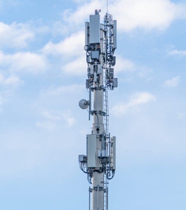 RF Communication transmission towers under cloudy sky in city