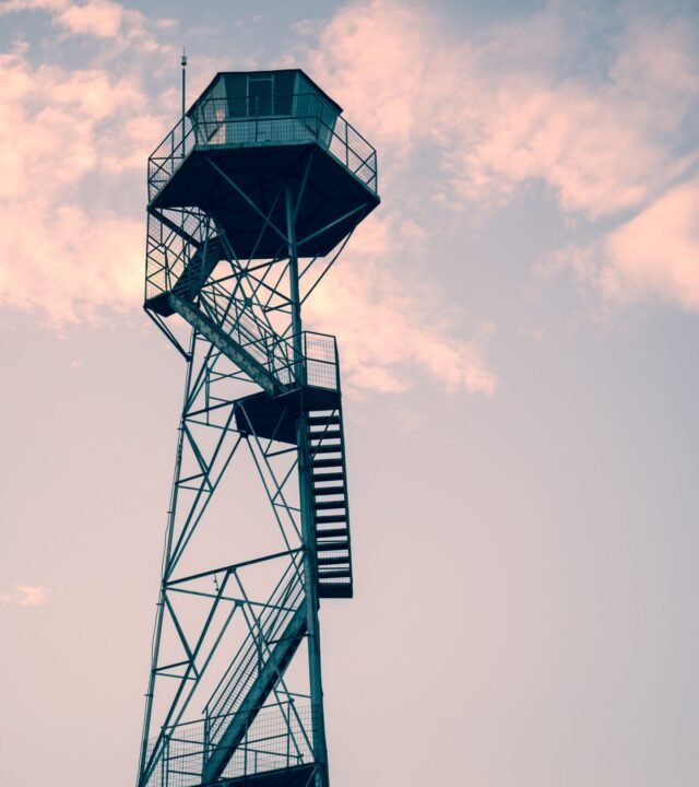 A vertical shot of an observation tower under the beautiful sunset sky